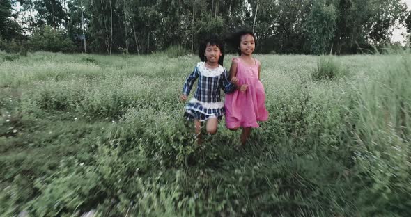 4K Two little girls running around the park alt