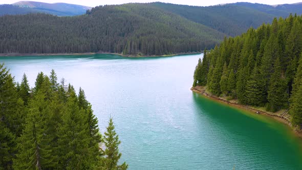 Aerial View on the lake between mountain forest. Over crystal clear mountain lake water. Fresh water alt