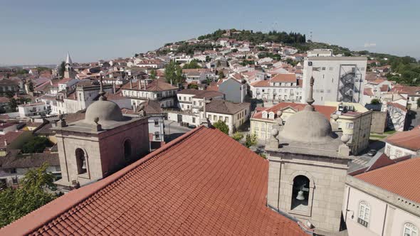 Aerial backwards view of rooftops in scenic Castelo Branco, Portugal. alt