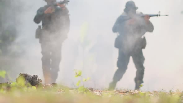 Group of soldier walk through fog from war fighting and they point gun to different direction alt