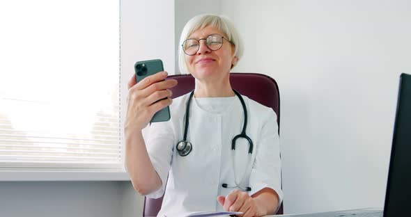 Woman doctor consulting patient using phone video call distant. Medical worker talking to client alt
