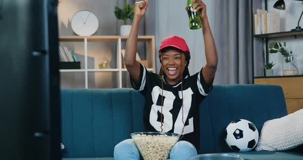Dark-Skinned Female Fan which Celebrating Victory of Favourite Team with Raised hands alt