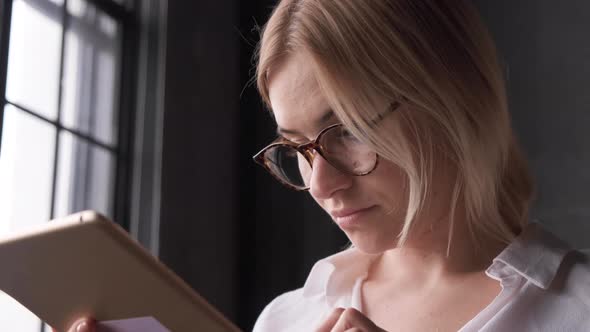 Attractive young woman working in a touchscreen computer or tablet alt