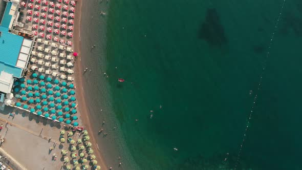 Amalfi, Italy, top aerial view of the beach with people and umbrellas on the shore on a beautiful su alt