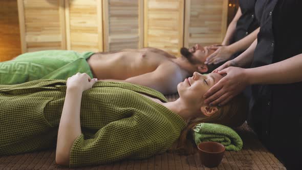 Relaxing Couple at Beauty Spa Treatment Getting Head and Facial Massage