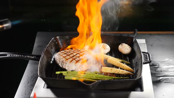 Professional Chef Cooking Flambe Style Dish on Restaurant Kitchen alt