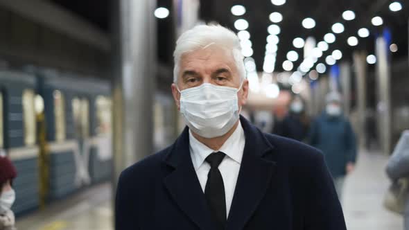 Stylish Businessman in Black Coat and Face Mask Walks on Underground Station