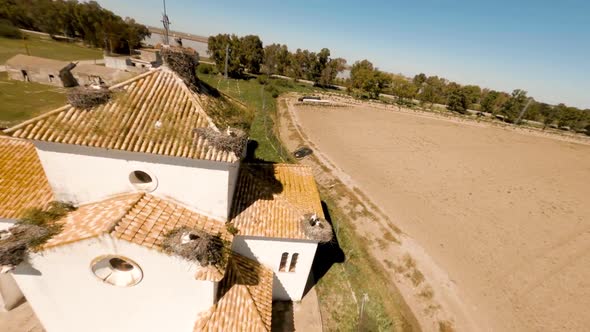 Aerial circles in the hermitage of la señuela with storks in their nests on the roof. alt