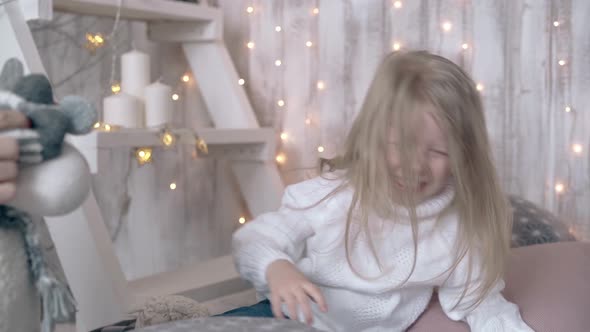 Child with Long Blond Hair Plays with Winter Themed Toys alt