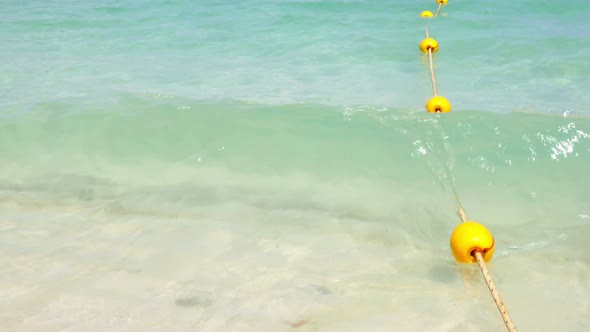 Yellow Buoy with Wave on the Beach  alt