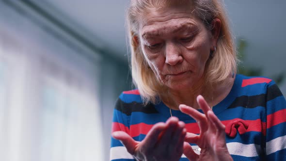 Elderly Woman Counting Coins in Wrinkled Hands alt