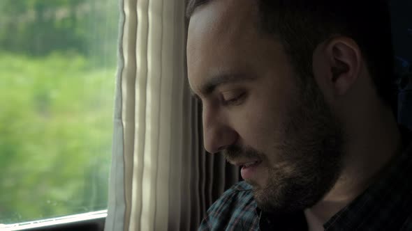 Man Finishes Call and Looking in the Window of the Train alt