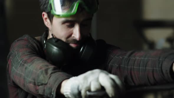 A Worker at the Factory Straightens the Machine alt