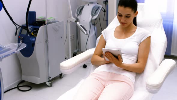 Female patient using digital tablet in clinic alt