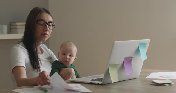 The Mother with Glasses Is Working on a Laptop and Analyzing the Diagram alt