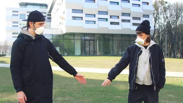 Young Millenials in Masks Showing with Arms To Keep Distance While Pandemic alt