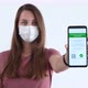 Woman in Face Mask Showing Certificate of Vaccination on a Mobile Phone - VideoHive Item for Sale