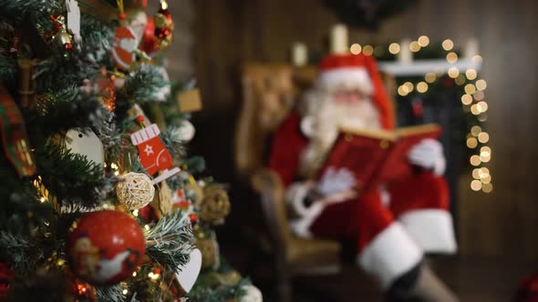 Blurred Santa Claus Hold Old Red Silk Album Near Christmas Tree with Toys and Lights alt