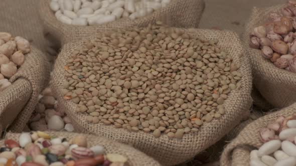 Dry lentils legumes falling on jute bowl. Mediterranean diet, vegan vegetarian ingredient healthy pr alt