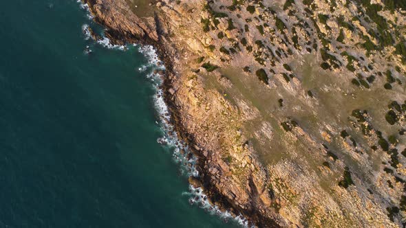 Vibrant tropical coastline of Vietnam with foamy sea waves, aerial top down view alt