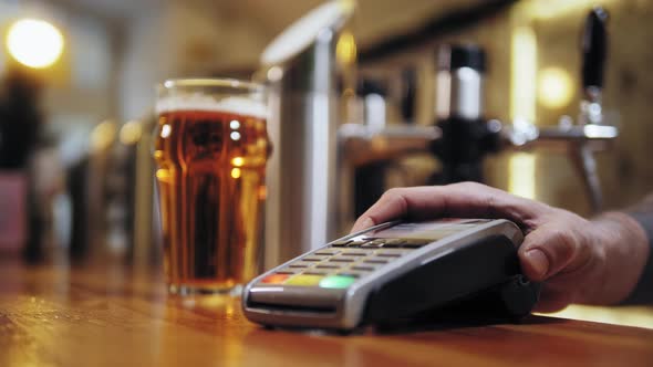 Buying Beer and Paying By Smartwatch Via Terminal Closeup alt