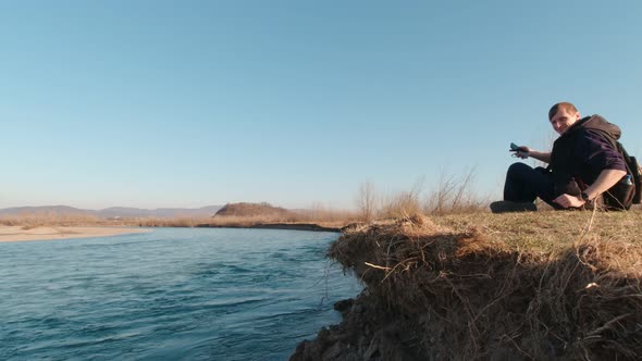 Man Sitting On The River Bank alt