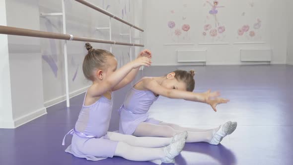 Cute Little Ballerinas Stretching Together at Dancing School Together