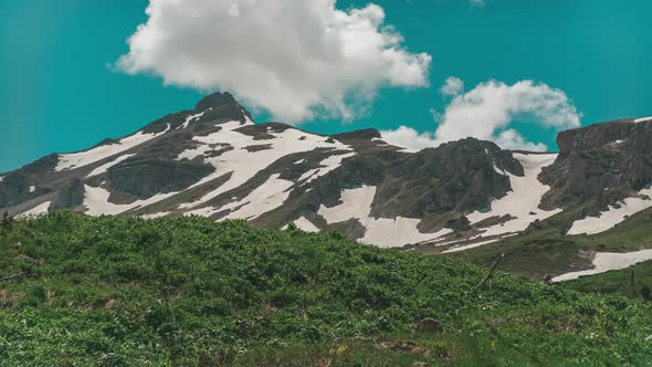 Oshten Mountain Partly Covered with Snow with Green Valley on Clear Sunny Day alt