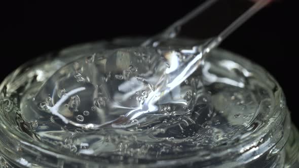 Woman Trying with Spoon Cosmetics Serum Facial Fluid Gel, Hyalurinic Acid Cream alt