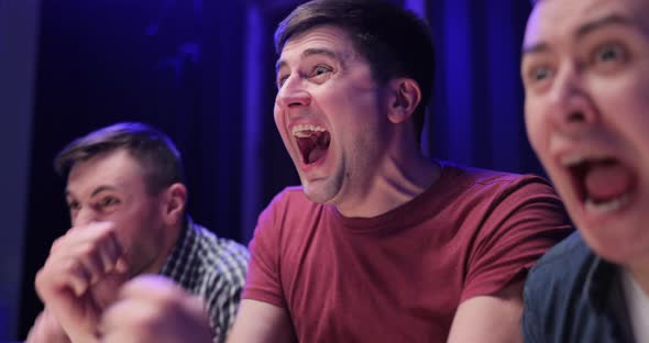 Close up of Caucasian Male Football Fan Sitting With Friends at TV Screen Watching Match alt