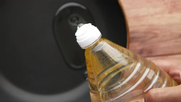 Pouring Sunflower Oil on a Cooking Pan Top View alt