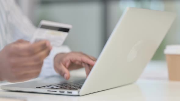 Close Up of African Man Making Online Payment on Laptop alt