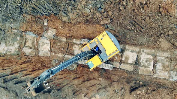 Tractor Uses Backhoe While Working at a Quarry. alt
