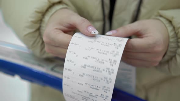 The Buyer Holds a Purchase Receipt in His Hands Checks Purchases and Prices
