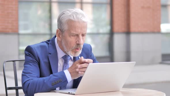 Online Video Chat on Laptop By Old Businessman Sitting Outdoor alt