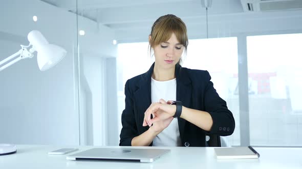 Young Female Using Smartwatch at Work in Office alt