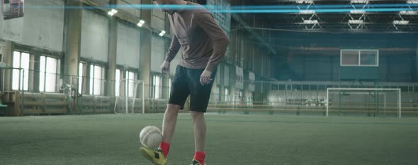 Sportsman Juggling Soccer Ball on Indoor Field alt