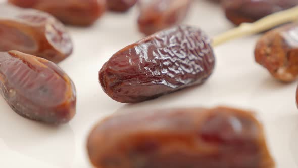 Phoenix dactylifera exotic fruit on white background slow tilt 4K 2160p UltraHD footage - Date palm  alt