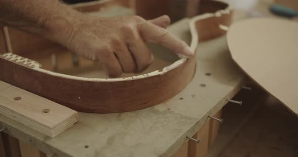 finger smearing glue on a guitar mold
