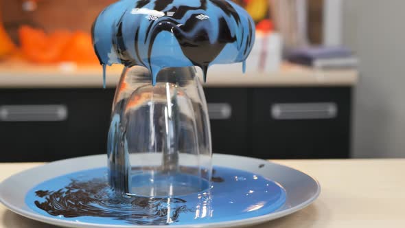 Drops of Blue Mirror Icing Dripping From a Freshly Poured Mousse Cake