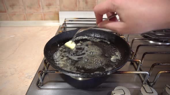 Cooking Eggs in a Skillet Pan with Butter Cast Iron Skillet on a Home Stove alt