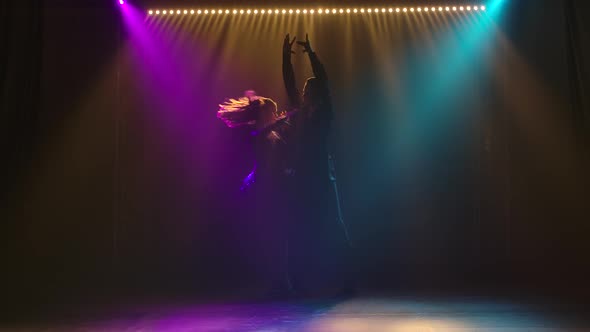 Ballroom Dance Performed By a Young Passionate Couple. Silhouette of Men and Women in a Dark Studio alt
