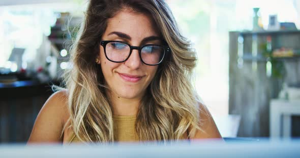 Young Woman Working on Computer in Cafe alt