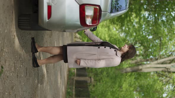 Silver Sedan Stands on Dirt Road alt