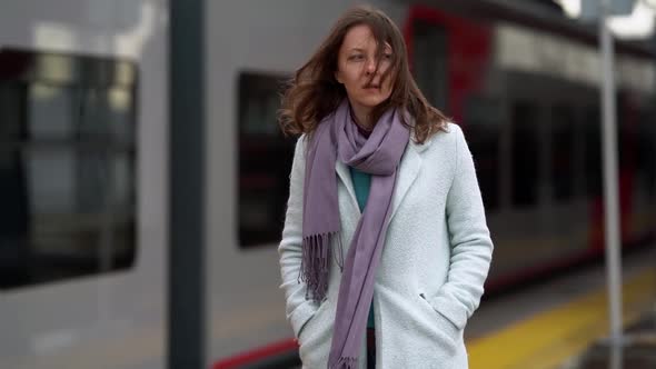 Thoughtful Woman Is Walking Over Open Platform of Train Station at Autumn Day alt