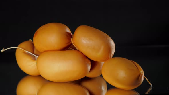 Brown Sausages with Thread Lie on Table Reflected on Glass alt