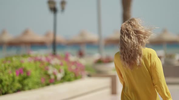 Happy Blonde Woman with Fashion Sunglasses is Walking on Sunny Street in Summer alt