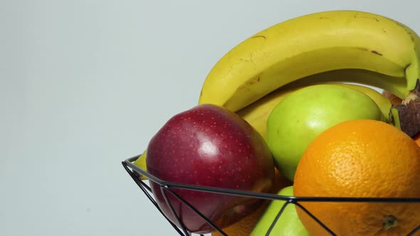 Rotating Fruit Basket with Fresh Bananas Apple Orange and Grapefruit for a Healthy Lifestyle alt