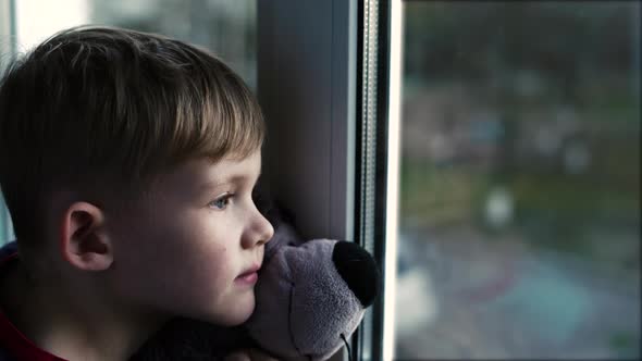 Sad Little Boy Lonely Child With Bear Near Looking Through Window The Little Boy