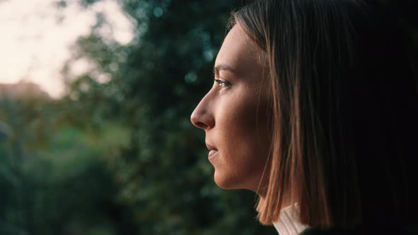 Girl in Nature Looking at the Horizon at Sunset, close-up handheld.
